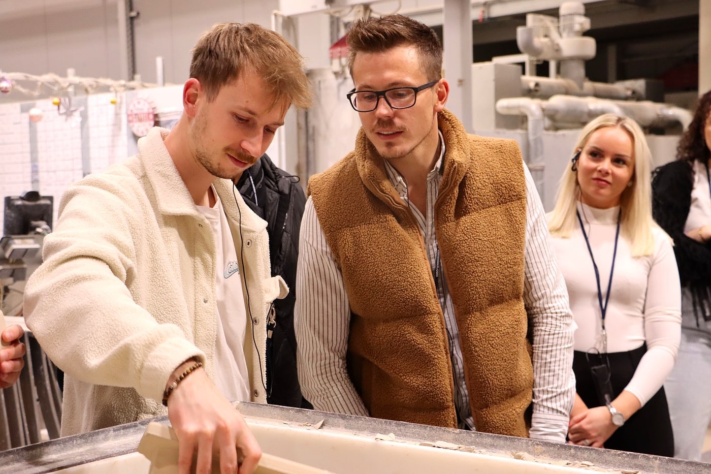 Junioren zu Gast in der Fertigung eines Herstellers: Teilnehmer begutachten Material am Werktisch