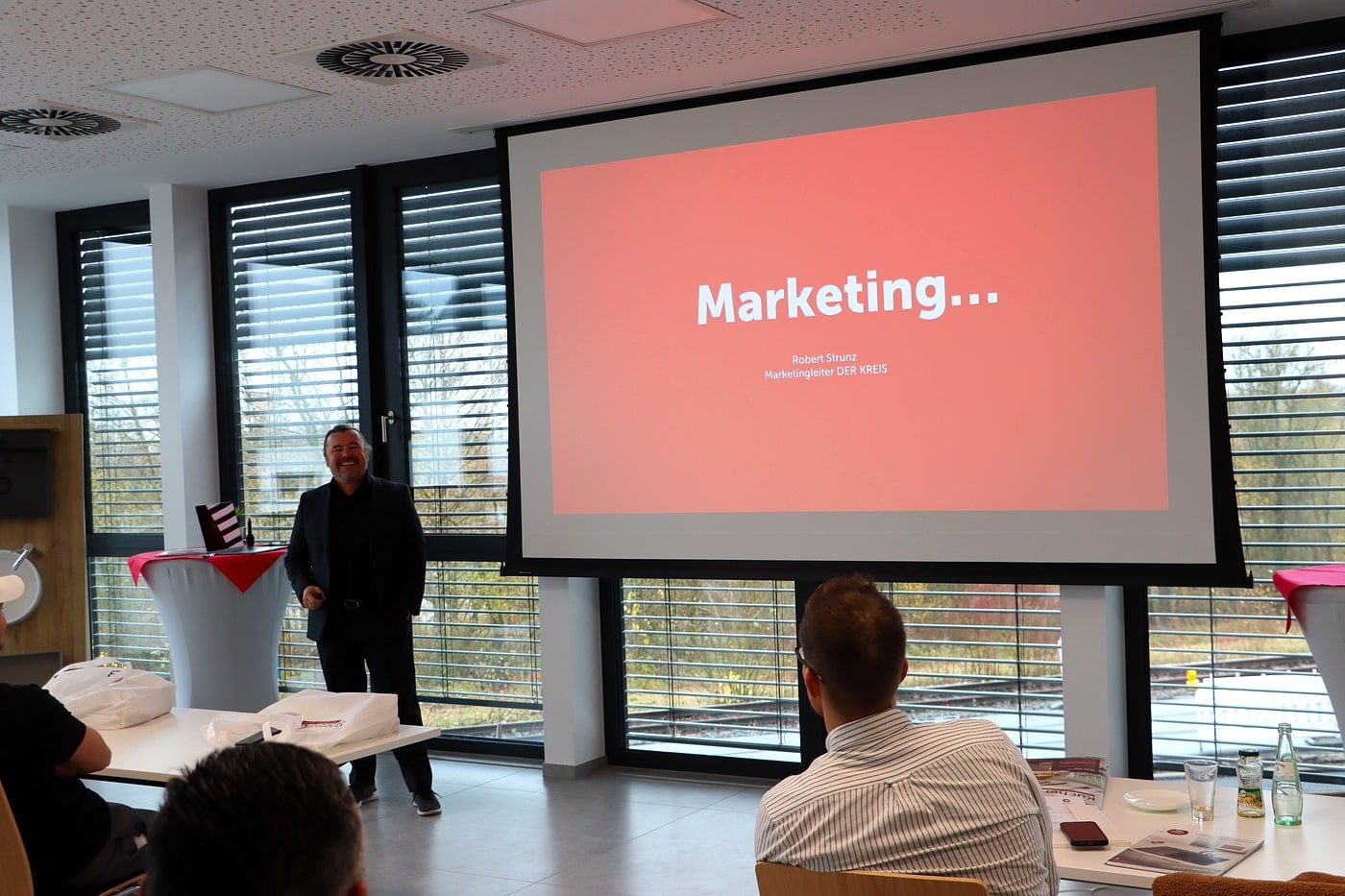 Seminar beim Junioren-Treffen: Marketing-Vortrag auf großer Leinwand vor Teilnehmern