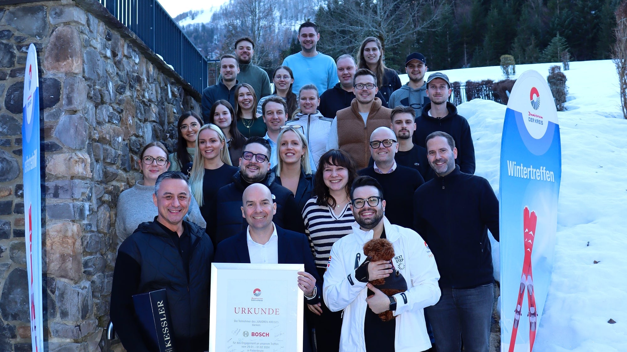 Gruppenfoto beim Junioren-Wintertreffen: Teilnehmer mit Urkunde vor der DER KREIS Junioren-Fahne im Schnee
